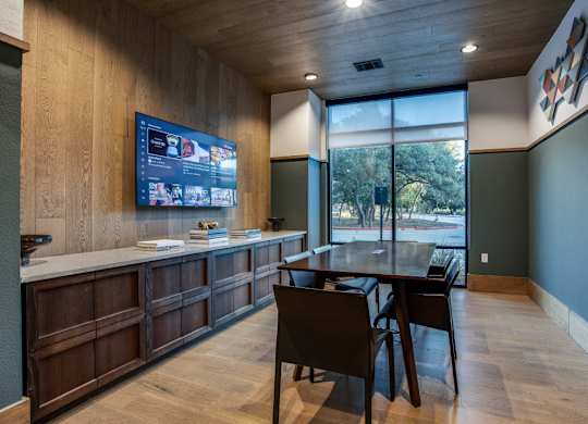 A modern room with a wooden floor and a television on the wall.