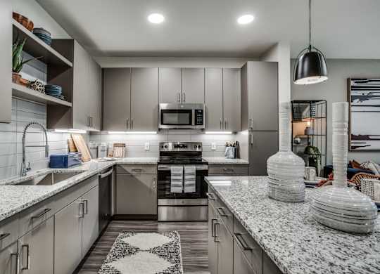 A modern kitchen with granite countertops and stainless steel appliances.
