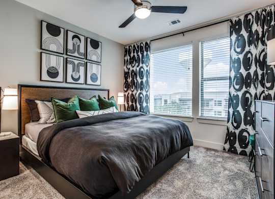 A bedroom with a large bed and a ceiling fan.
