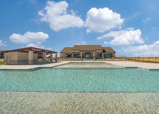 A large swimming pool in front of a house.