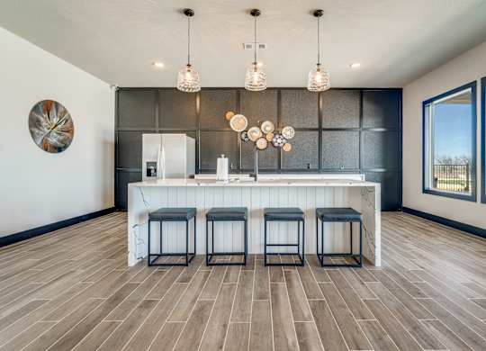 A kitchen with a bar and stools.