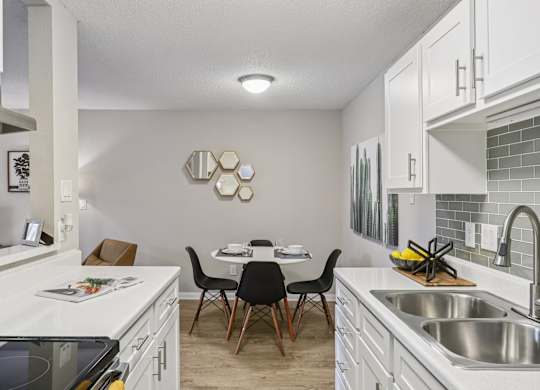 A kitchen with a table and chairs in the middle.