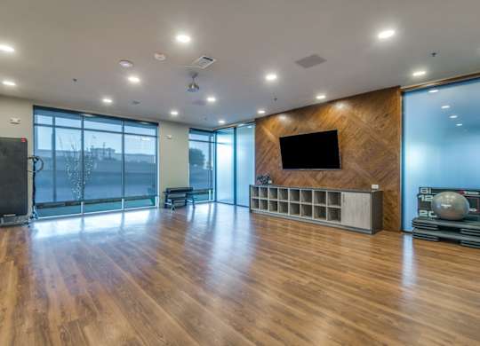 A spacious room with wooden floors and a large window.