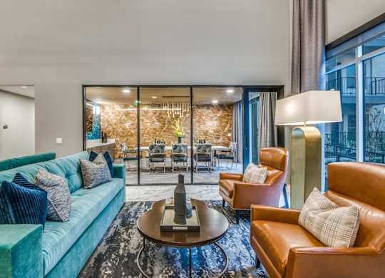 A living room with a blue couch and a brown armchair.