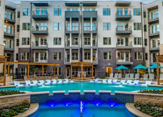 A large apartment complex with a pool in the foreground.