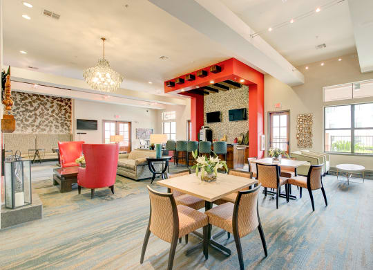 a large lobby with tables and chairs and a red pillar