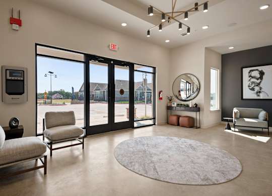 A well-lit room with a chair, a sofa, and a mirror.
