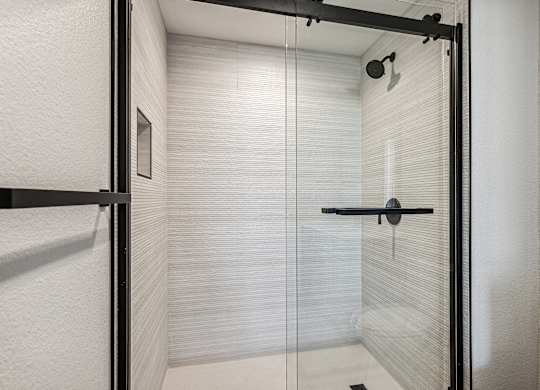 A white bathroom with a glass shower door.