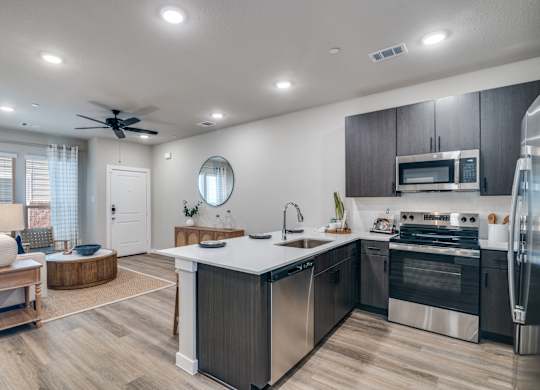 A modern kitchen with a large island and stainless steel appliances.