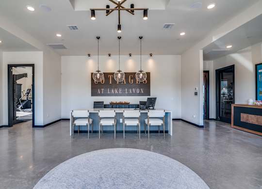 A modern dining room with a large table and chairs.
