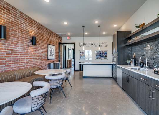 A modern kitchen with a bar area and a dining table with chairs.