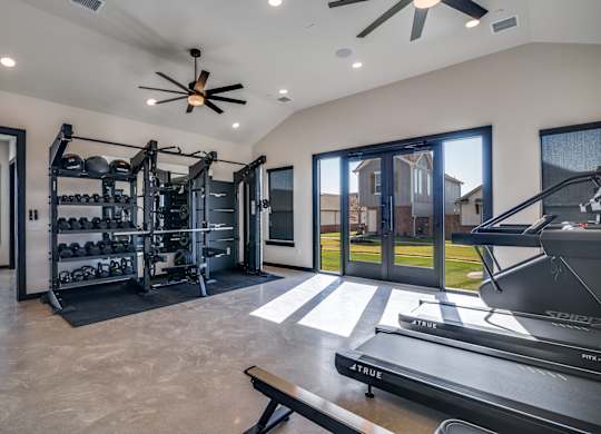 A modern home gym with a treadmill, weights, and exercise equipment.
