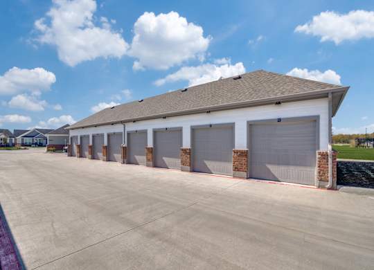 A long building with a grey roof and grey garage doors.