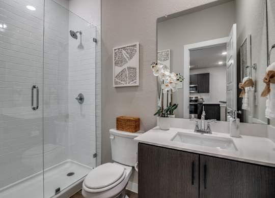 A bathroom with a toilet, sink, and shower.
