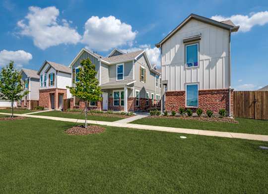 A row of houses with a green lawn in front.