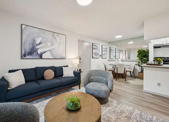 A living room with a blue couch and a grey armchair.