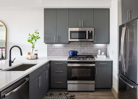 A modern kitchen with a stove, oven, and refrigerator.