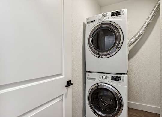 A white washing machine and dryer in a small laundry room.