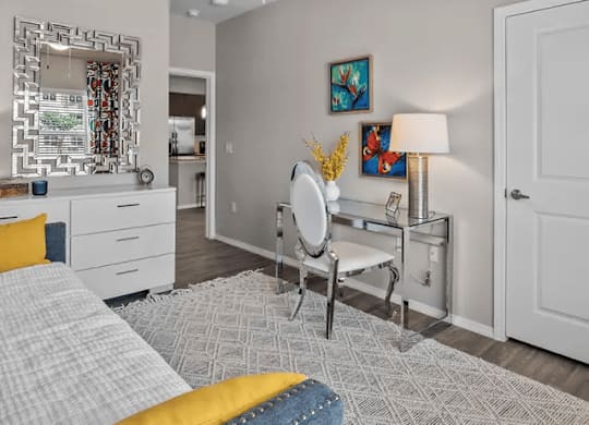 A bedroom with a bed, a desk, and a ceiling fan.