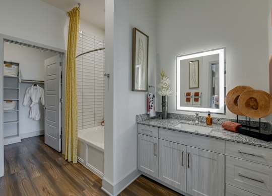 A bathroom with a white tub and a yellow curtain.