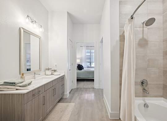 A bathroom with a white tub, sink, and shower.