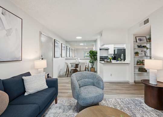 A living room with a blue couch and a grey armchair.