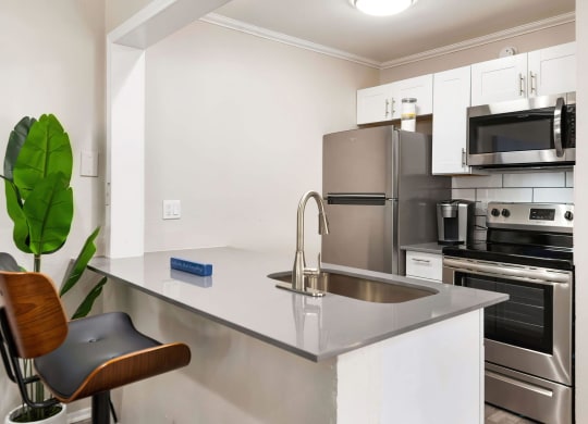 a kitchen with white cabinets and stainless steel appliances