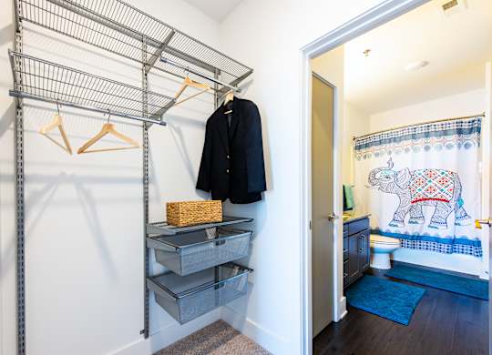 A closet with a black jacket hanging on a hanger.