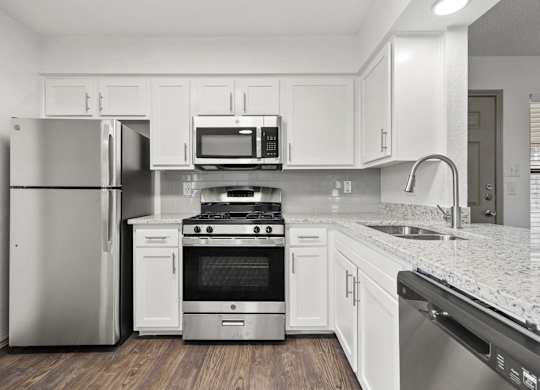 A kitchen with white cabinets and stainless steel appliances.