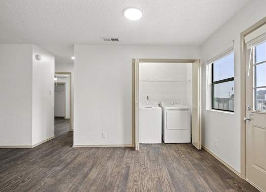 A white room with a washer and dryer in it.