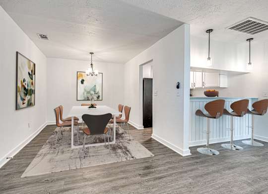 A dining room with a white table and chairs.