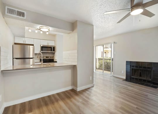 a living room with a fireplace and a kitchen