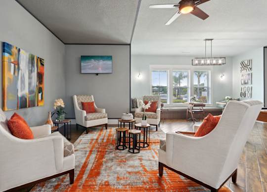 A living room with a white couch and orange pillow.