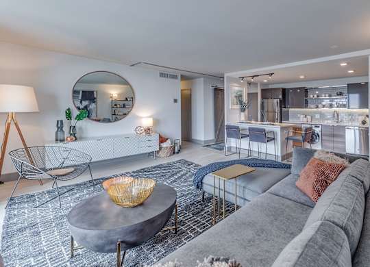 A modern living room with a grey sofa and a round coffee table.