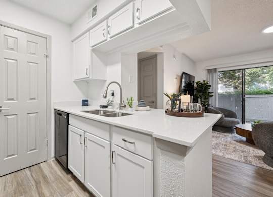 A white kitchen with a sink and a window.