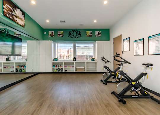 A room with exercise bikes and pictures on the wall.