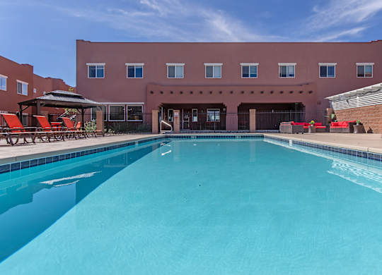 A large swimming pool in front of a red building.