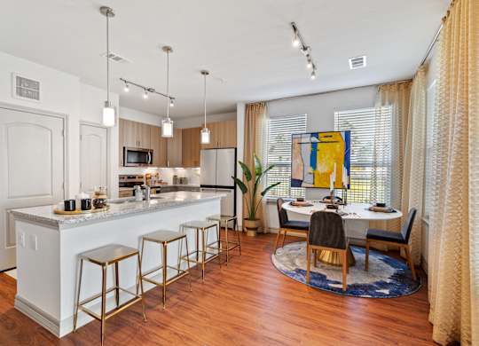 A kitchen with a white counter and bar stools.