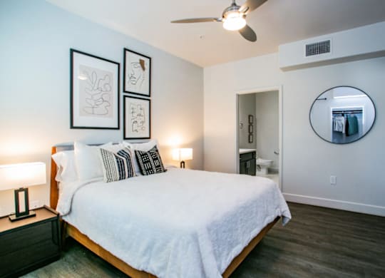 A bedroom with a bed, nightstands, and a mirror.
