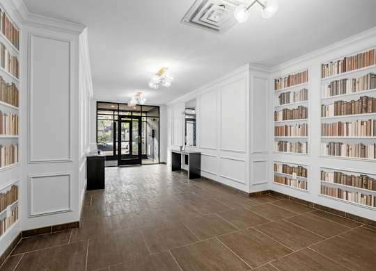 A room with white bookshelves filled with books.