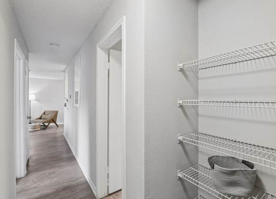 A hallway with a shelf on the right side.
