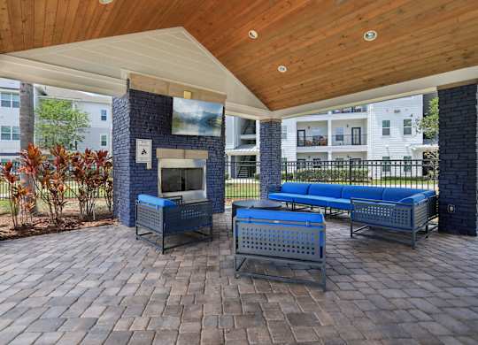 A patio with a grill and seating area.