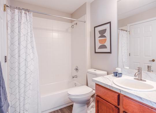 A bathroom with a toilet, sink, and shower.