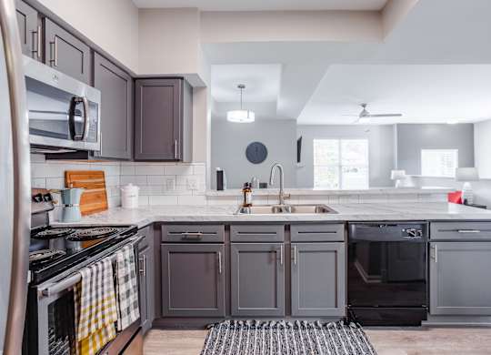 A modern kitchen with dark brown cabinets and a white countertop.