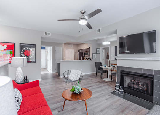 A living room with a red couch and a fireplace.