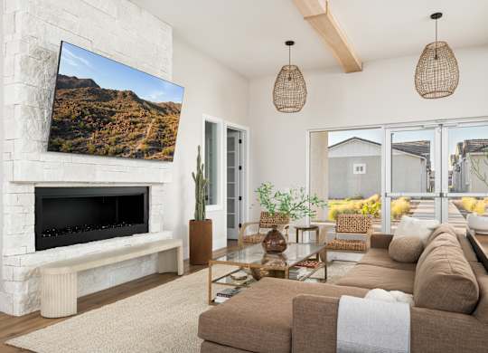 A living room with a fireplace and a large screen TV mounted on the wall.