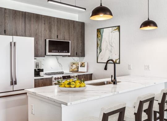 a kitchen with a white counter top with a bowl of fruit