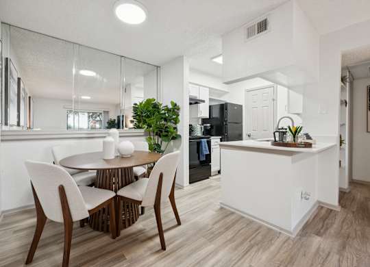 A modern kitchen with a dining table and chairs.