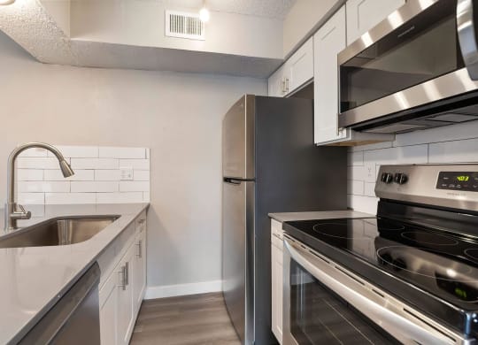 a kitchen with white cabinets and stainless steel appliances