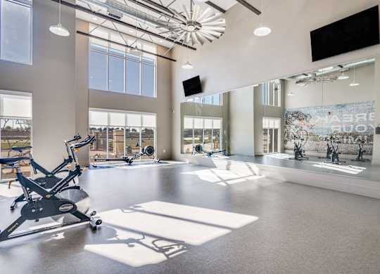 A gym with a treadmill, exercise bike, and other equipment.